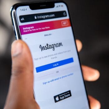 Una mano tiene un telefono con instagram.com aperto nel browser, fuori dall applicazione