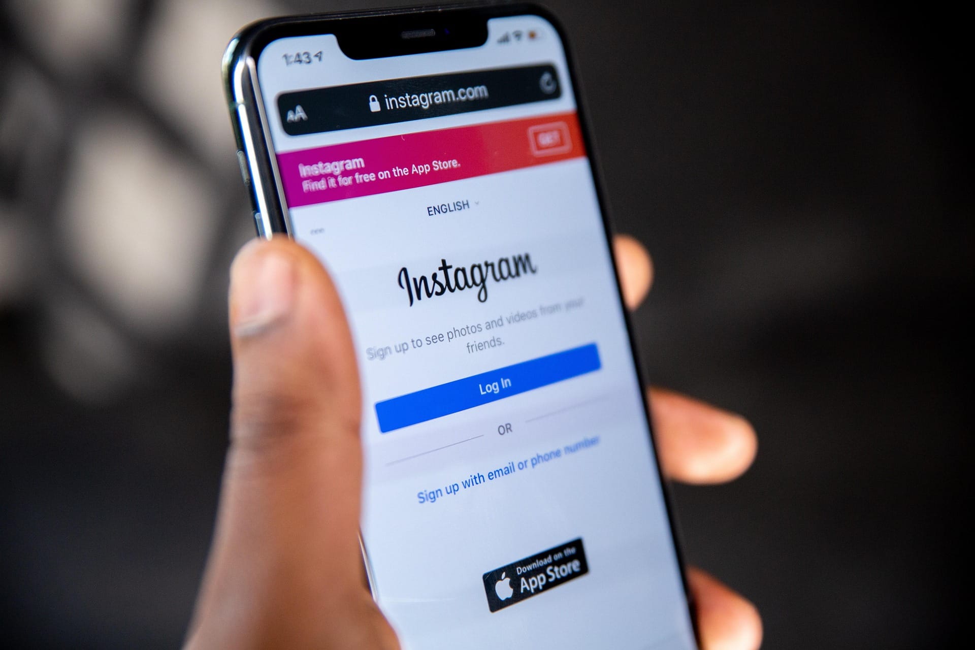 Una mano tiene un telefono con instagram.com aperto nel browser, fuori dall applicazione