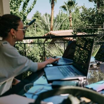 Business che dipende da te: donna che lavora al portatile in terrazza durante le vacanze