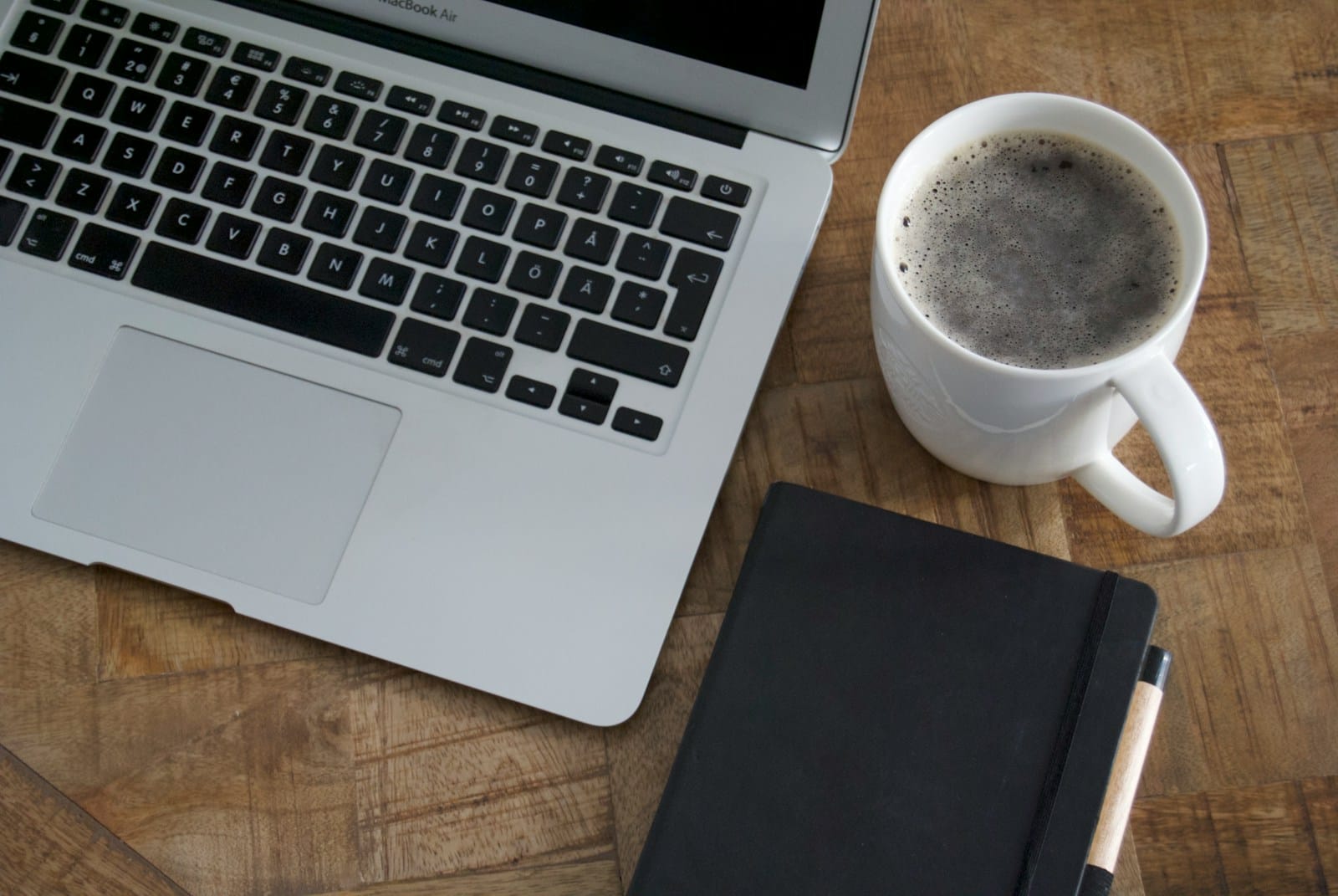 Scrivania con portatile e quaderno: smontare un business che dipende da te con poche ore a settimana