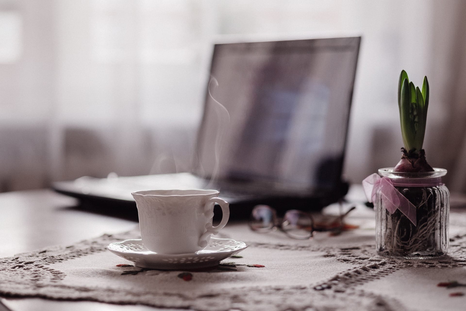 Tazza di caffè e portatile su un tavolo di casa, la mattina in cui si decide di creare il sito da sola