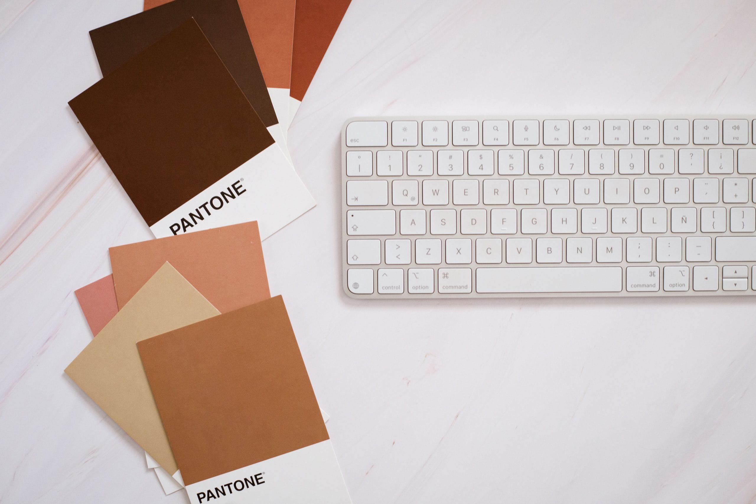Personal branding online: cartelle di colori Pantone accanto a una tastiera bianca